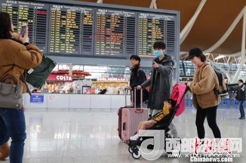 旅客帶著孩子前往辦票柜臺(tái)辦理登機(jī)手續(xù)?！∫罅⑶?攝
