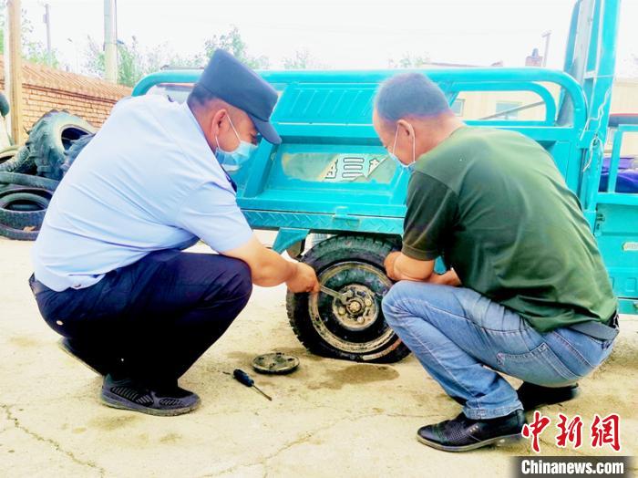 賽旦與民警共同維修三輪摩托車?！∫懒窘?攝