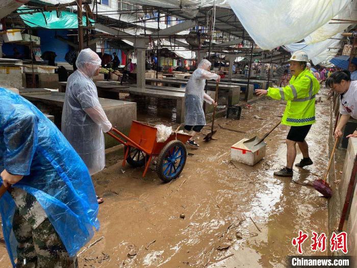 圖為7月26日，暴雨引發(fā)的洪水過境后，重慶萬州區(qū)分水鎮(zhèn)政府干部職工及志愿者清掃淤泥和垃圾?！　≈貞c萬州區(qū)委宣傳部供圖 攝