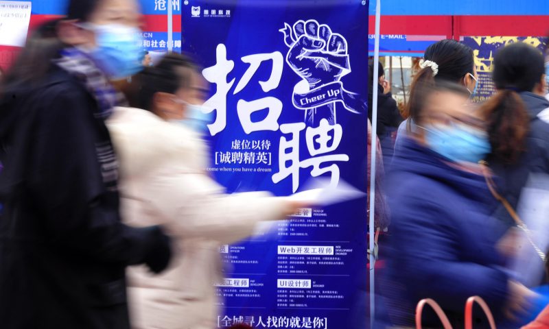 求職者從一家招聘企業(yè)的廣告牌前走過(guò)。新華社發(fā)（苑立偉 攝）