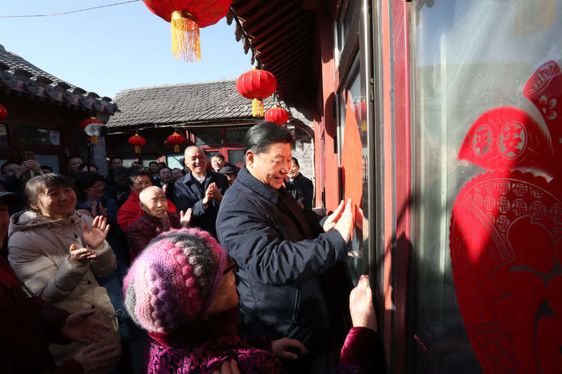 2019年2月1日上午，習(xí)近平在北京前門東區(qū)草廠四條胡同32號院，高興地拿起一幅“?！弊?，親自貼到門上，給這里的老街坊們拜年。新華社記者 鞠鵬 攝