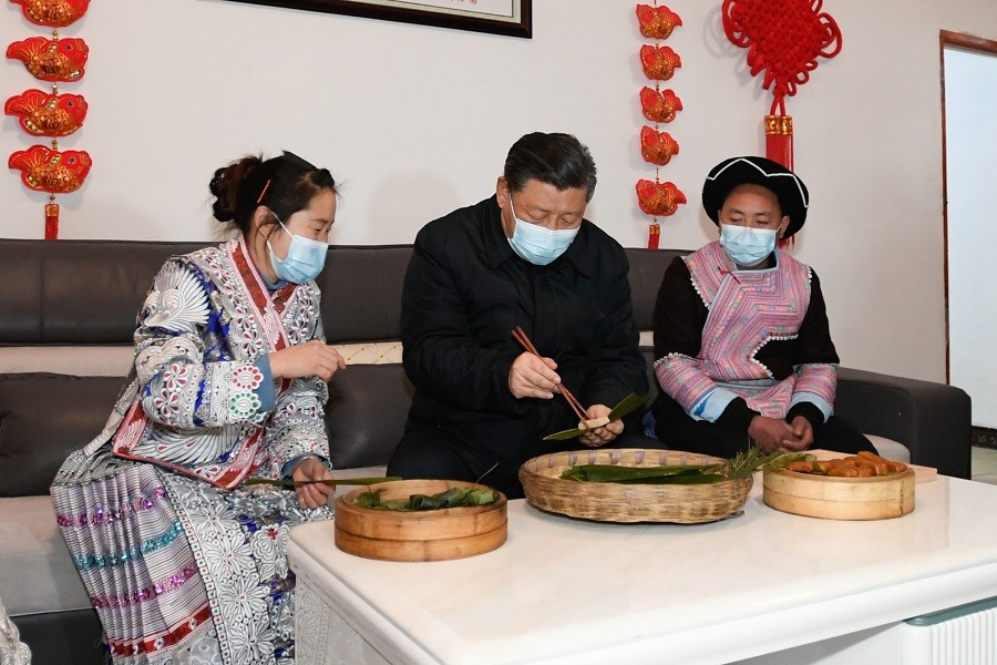 2021年2月3日下午，習近平在貴州畢節(jié)市黔西縣新仁苗族鄉(xiāng)化屋村苗族村民趙玉學家，同一家人邊聊家常邊制作當?shù)貍鹘y(tǒng)節(jié)日食品黃粑。新華社記者 李學仁 攝